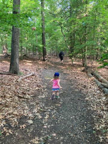 Adult and child running down the trail